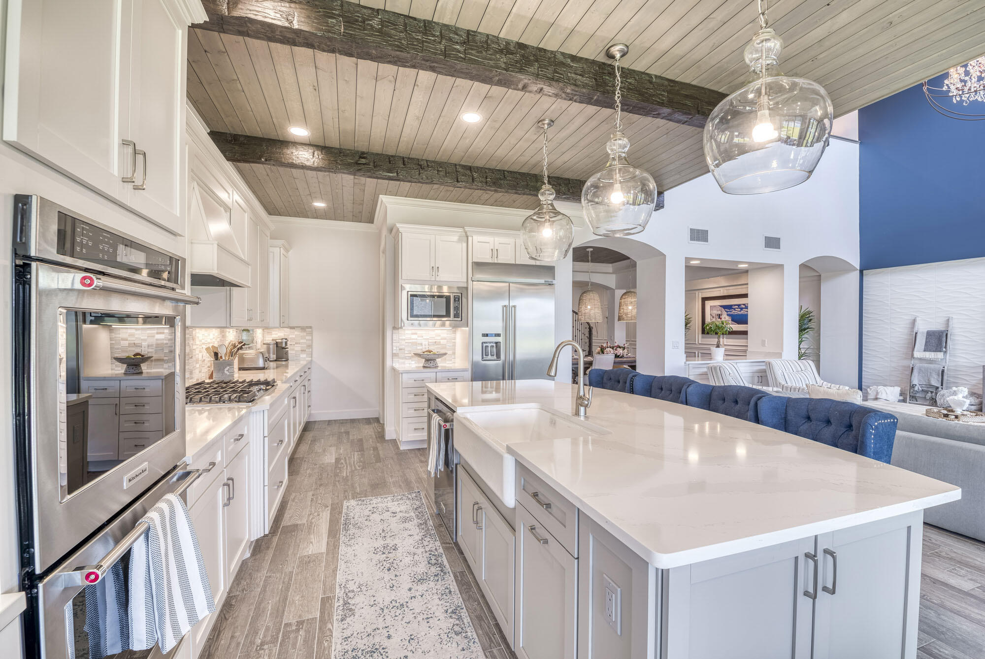 114 Cinder Dunes Point Jupiter, FL 33478 - Photo 9 of 62 a large kitchen with kitchen island a large island a stove a refrigerator a dining table and chairs with wooden floor