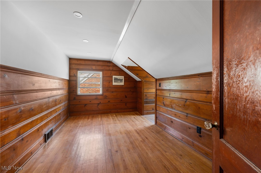 18122 Nottingham Road Cleveland, OH 44119 - Photo 18 of 29 Bedroom featuring vaulted ceiling, wooden walls, light wood-style floors, and recessed lighting