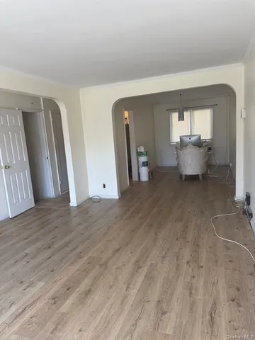 an empty room with wooden floor and a window