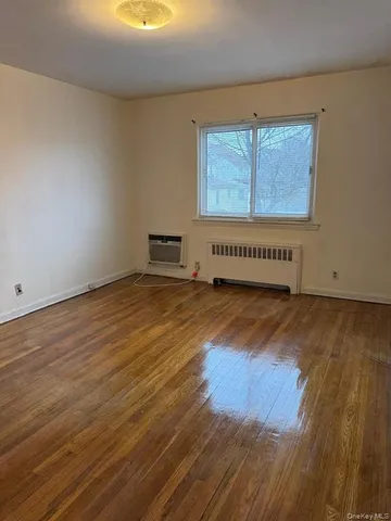 a view of a room with wooden floor and window