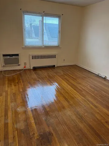 a view of a room with wooden floor and window