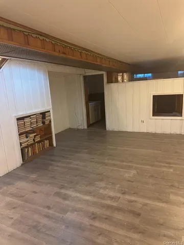 a view of an empty room with a fireplace and a window