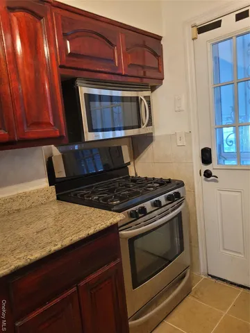a kitchen with granite countertop a stove and a microwave