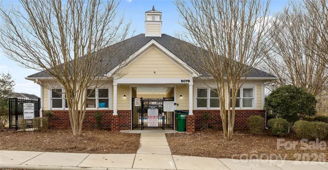 a view of a house with a large tree and a yard