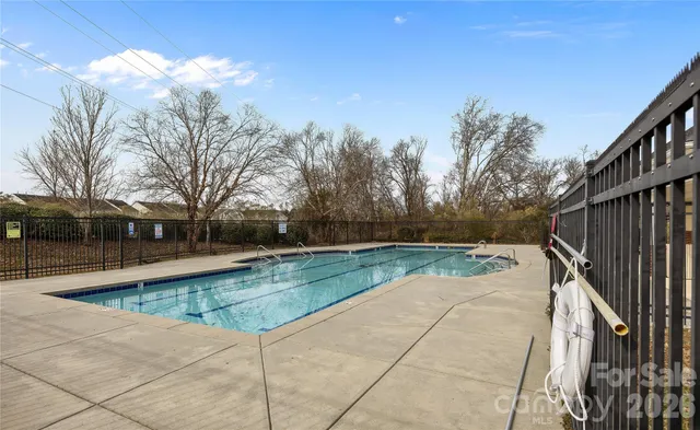 a view of backyard with swimming pool and seating