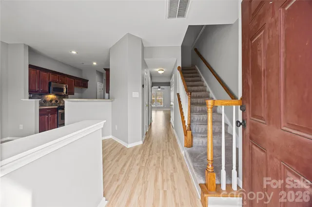 a view of a kitchen with wooden floor and electronic appliances