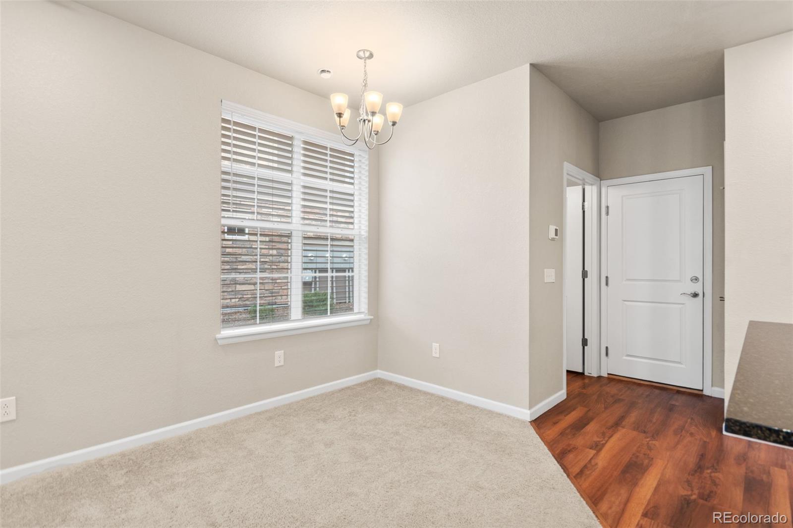 8417 Rizza Street, Unit A Littleton, CO 80129 - Photo 22 of 30 a view of an empty room with wooden floor and a window