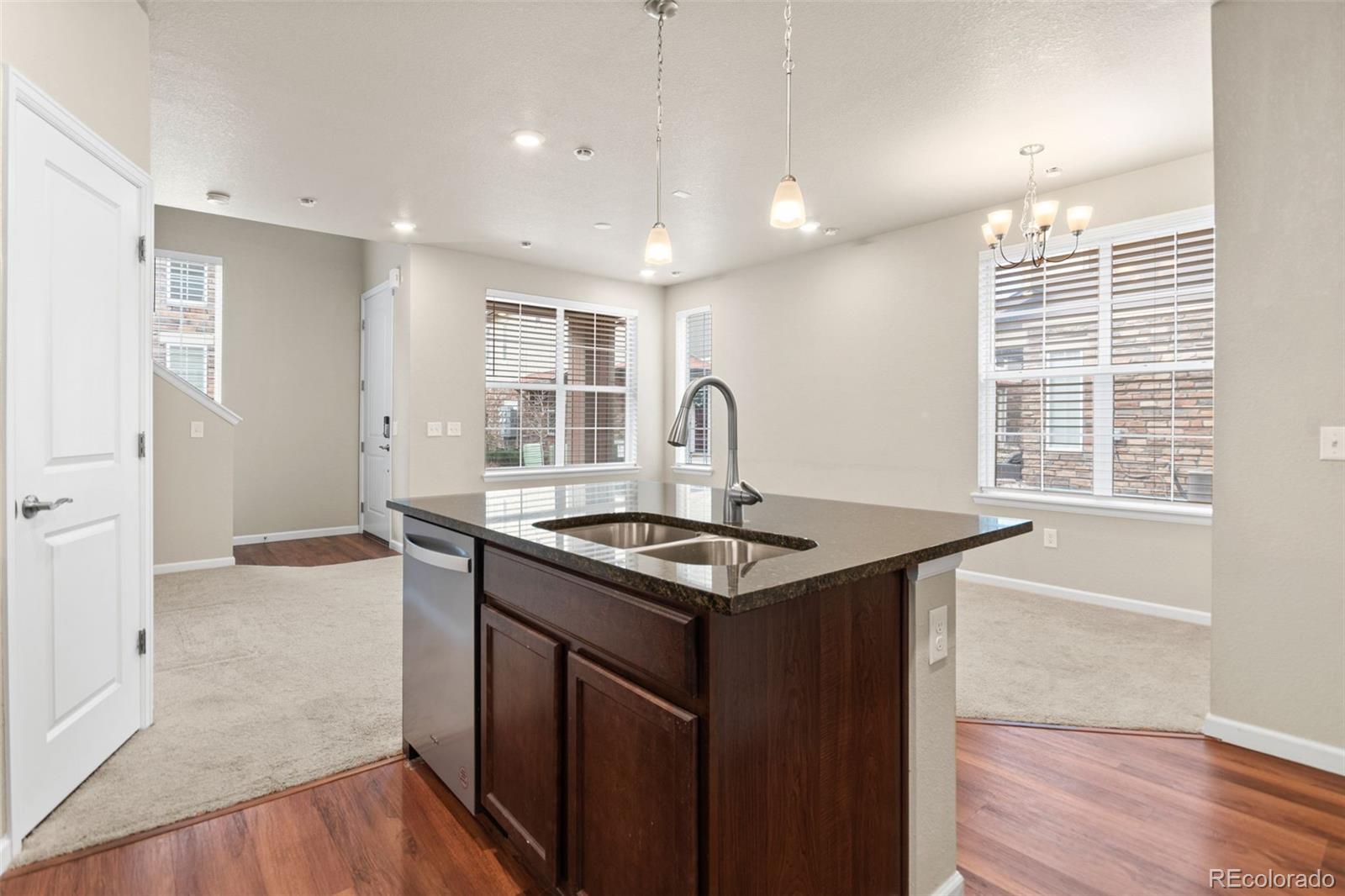 8417 Rizza Street, Unit A Littleton, CO 80129 - Photo 27 of 30 a kitchen with granite countertop a sink and a stove