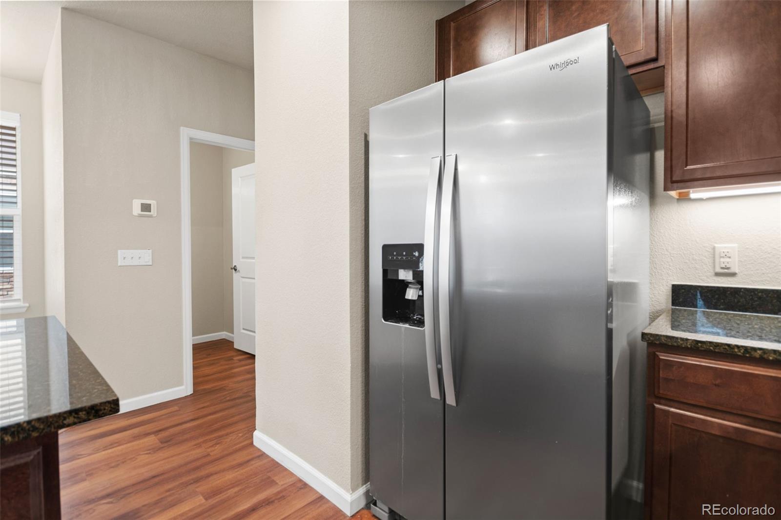 8417 Rizza Street, Unit A Littleton, CO 80129 - Photo 28 of 30 a kitchen with a refrigerator and wooden floor
