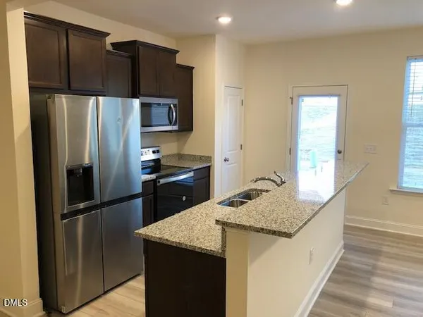 a kitchen with granite countertop stainless steel appliances a refrigerator and a counter space