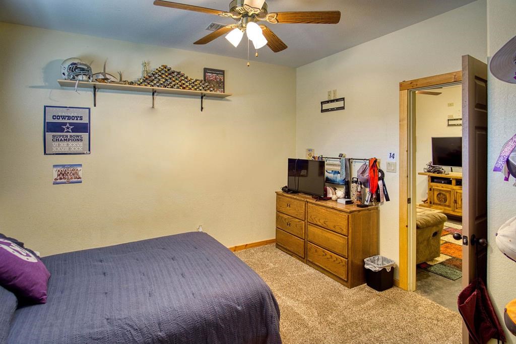 6446 Blackjack Road Fredonia, TX 76842 - Photo 36 of 48 a bedroom with a bed and a chandelier