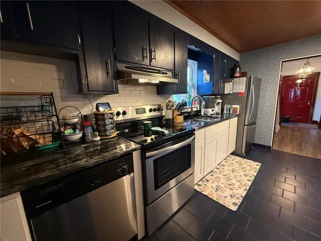 a kitchen with stainless steel appliances granite countertop a sink stove and cabinets