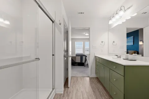 a en suite bathroom with a double vanity sink a mirror and a shower