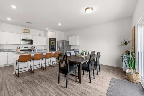 a living room with stainless steel appliances kitchen island granite countertop furniture and wooden floor