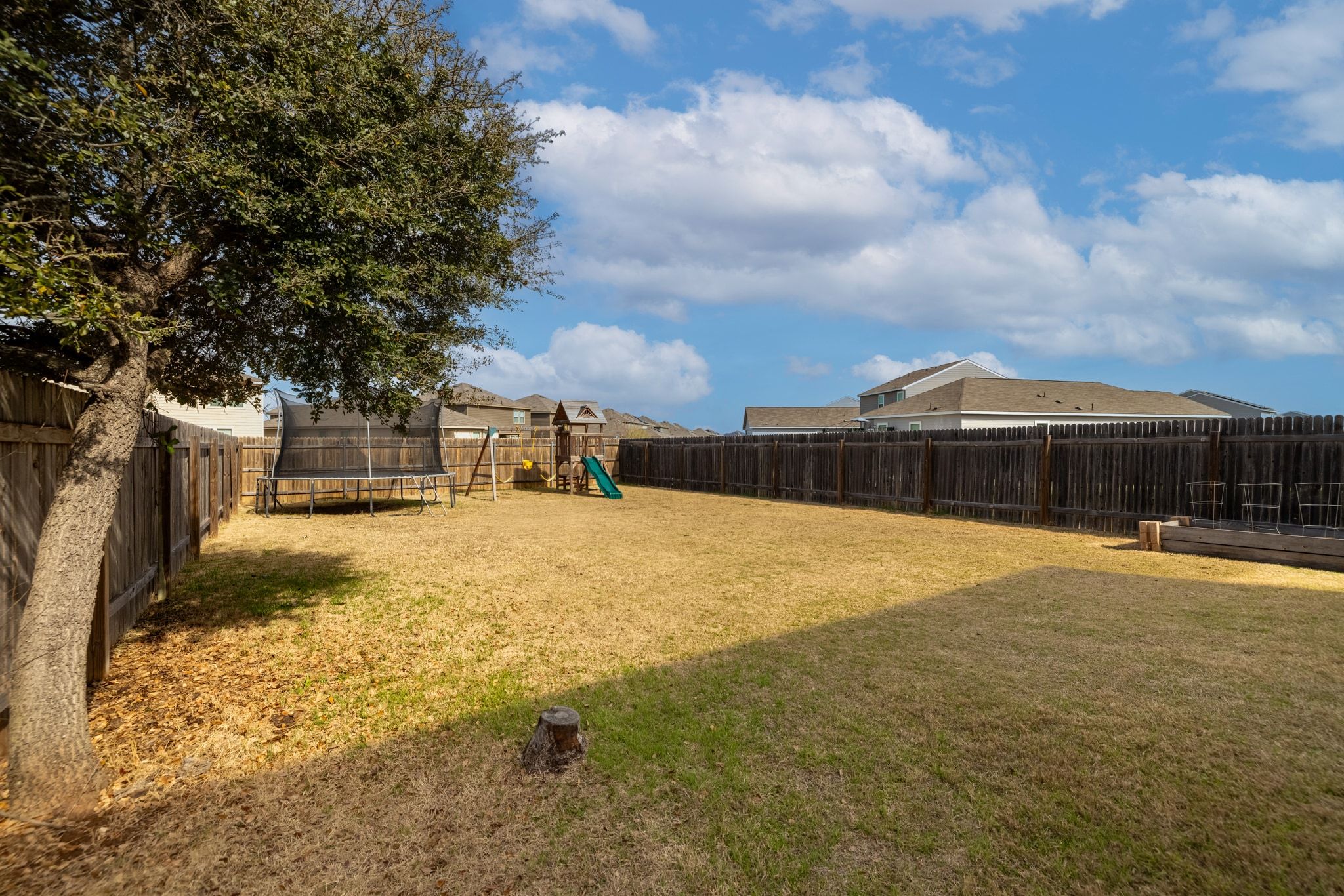 212 Wonderful Life Way Jarrell, TX 76537 - Photo 22 of 25 Fenced backyard featuring a trampoline, a playground, and a residential view