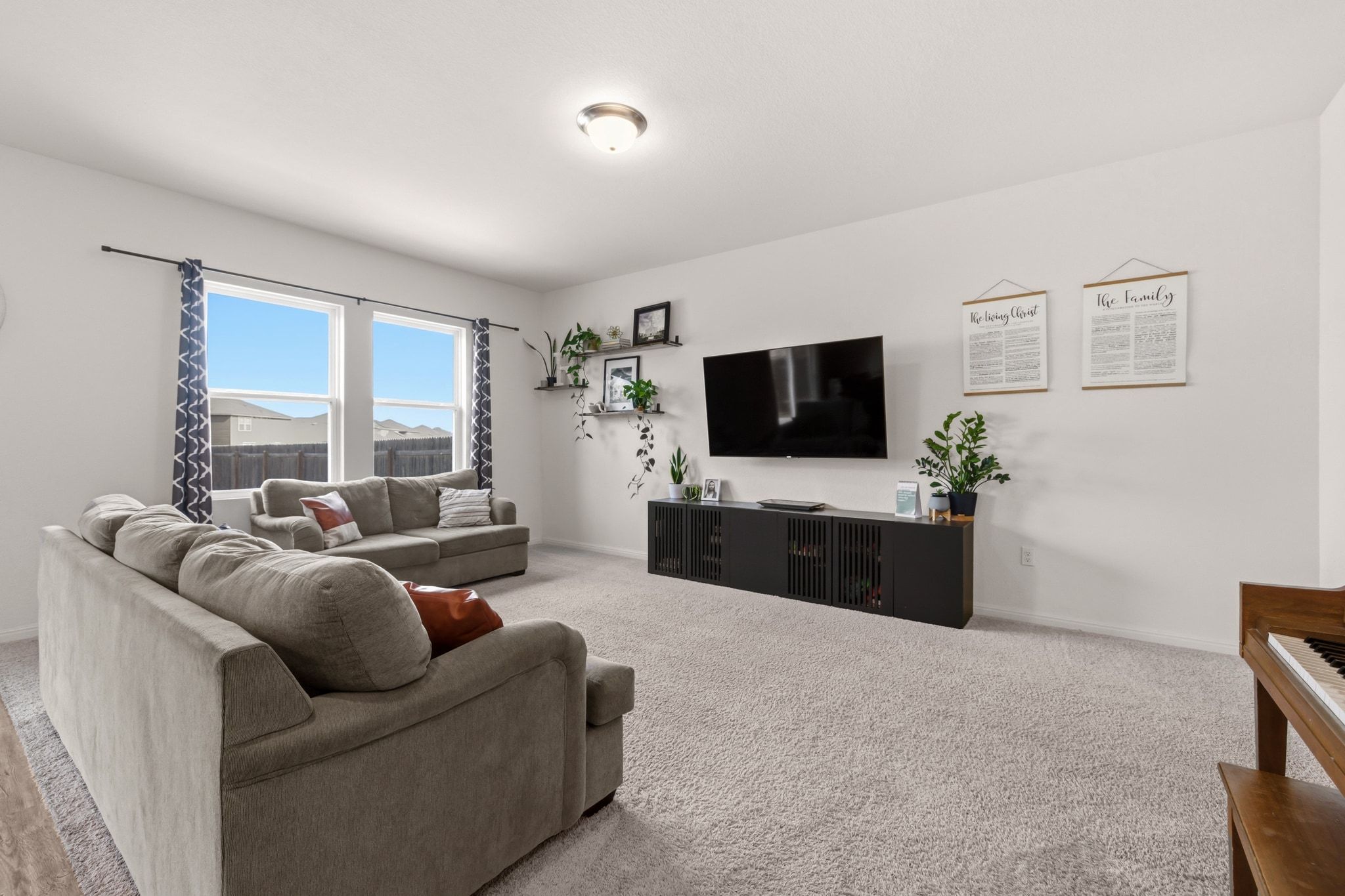 212 Wonderful Life Way Jarrell, TX 76537 - Photo 8 of 24 a living room with furniture a flat screen tv and a floor to ceiling window