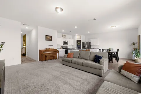 a living room with furniture and kitchen view