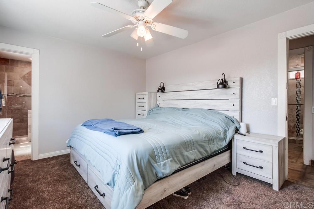 415 3rd Street Ramona, CA 92065 - Photo 16 of 33 a bedroom with a bed and a chandelier