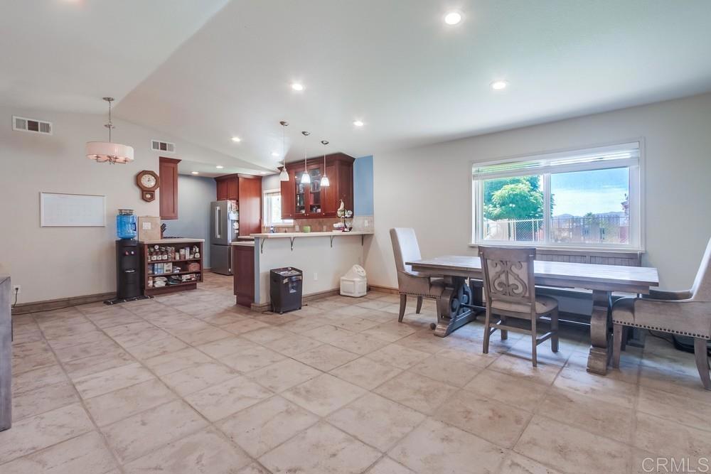 415 3rd Street Ramona, CA 92065 - Photo 7 of 33 a kitchen with stainless steel appliances a dining table chairs and a refrigerator