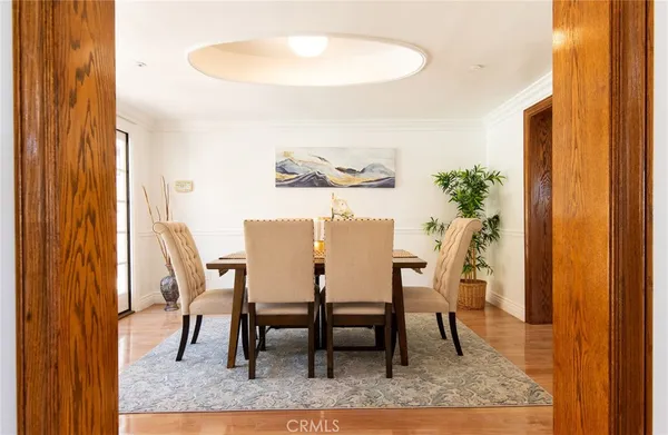a kitchen with granite countertop a refrigerator a stove a sink and white cabinets with wooden floor