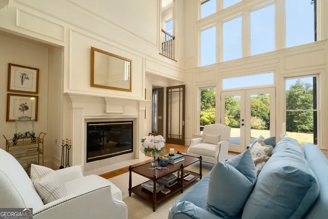 a living room with furniture fireplace and a large window