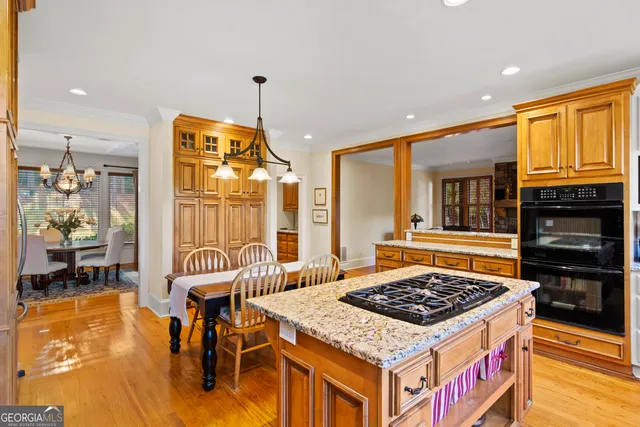 a kitchen with a stove a refrigerator and wooden floor