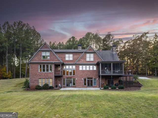 a view of a big house with a big yard and large trees