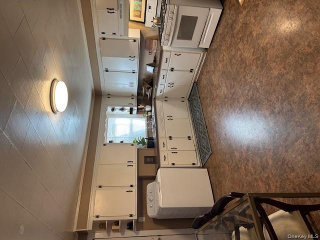 206 Mill Street, Unit 1 Poughkeepsie, NY 12601 - Photo 5 of 11 a kitchen with granite countertop a sink stove and white cabinets