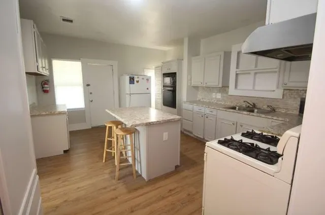 a kitchen with a table chairs refrigerator and cabinets