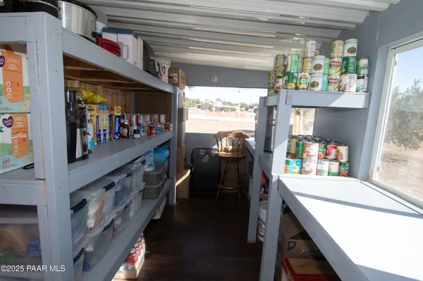 a kitchen area with stainless steel appliances wooden floor and window