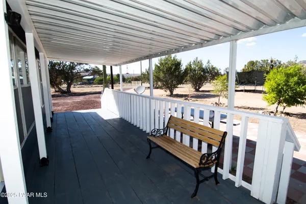 a view of a porch with furniture and a yard