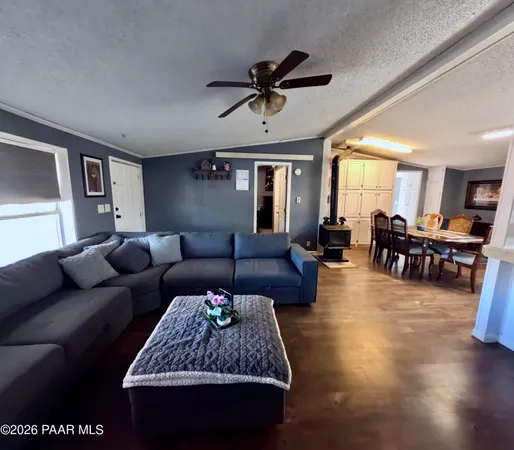 a living room with furniture and a view of kitchen