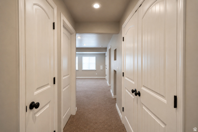 896 Cres Drive South Mapleton, UT 84664 - Photo 25 of 32 Carpeted hallway featuring multiple white paneled doors with black hardware, recessed lighting, and light-toned walls