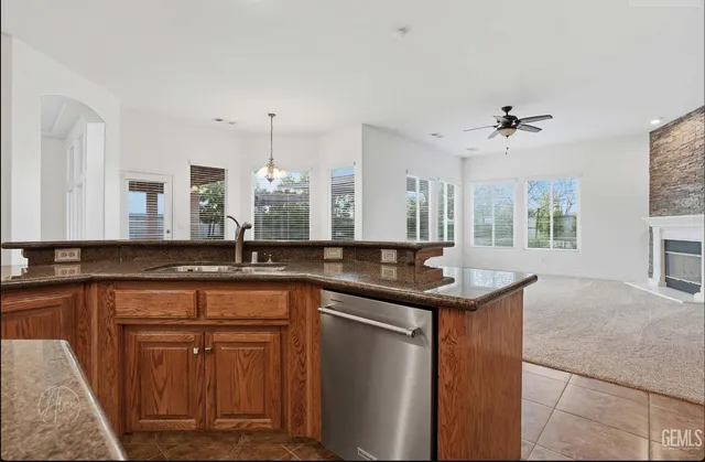 a kitchen with stainless steel appliances granite countertop a sink a counter space and a window