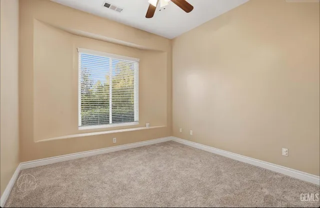 an empty room with a window and a fan