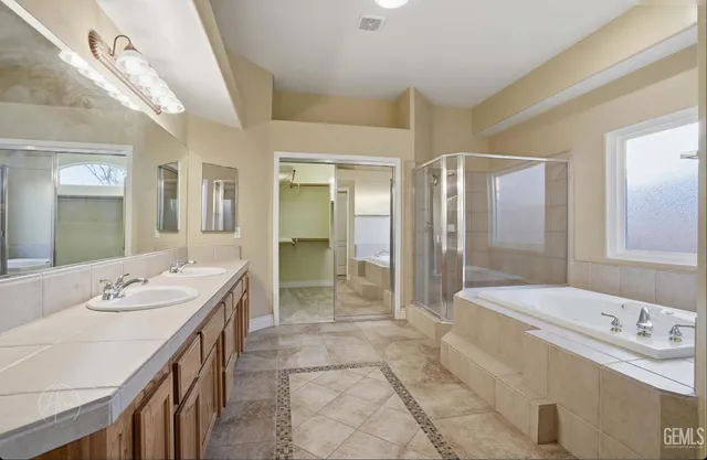 a spacious bathroom with a double vanity sink mirror and shower