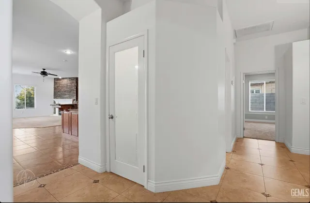 a view of a hallway with wooden floor and a bathroom