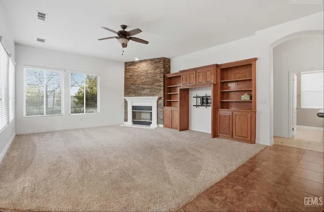 a view of an empty room with a fireplace and a window