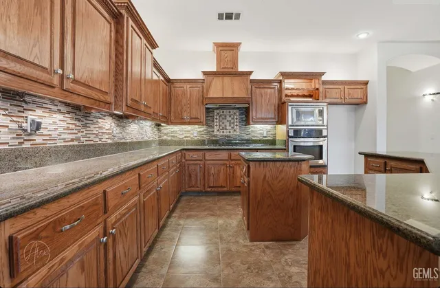 a kitchen with stainless steel appliances granite countertop a sink a stove and a cabinets