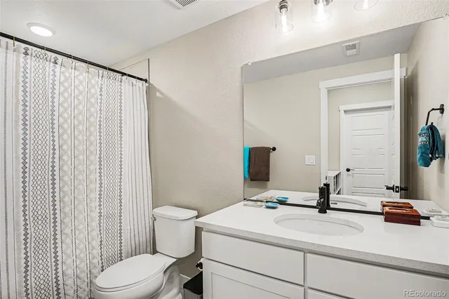 a bathroom with a sink a toilet and mirror