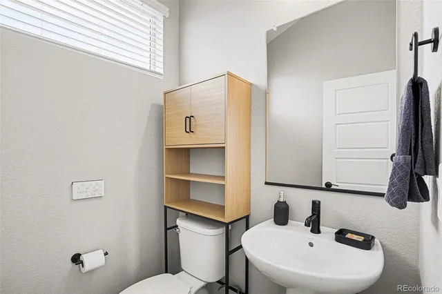 a bathroom with a sink a toilet and a mirror