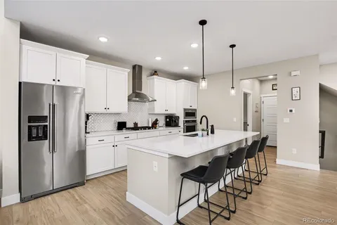 a kitchen with stainless steel appliances a refrigerator a stove a sink and a refrigerator