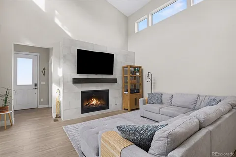 a living room with furniture a flat screen tv and a fireplace
