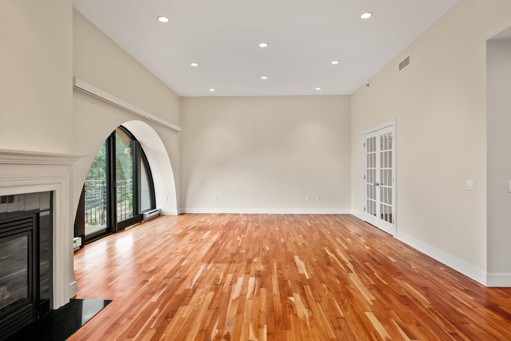 2420 Beacon Street, Unit 402 Boston, MA 02467 - Photo 15 of 29 a view of a livingroom with wooden floor and a fireplace