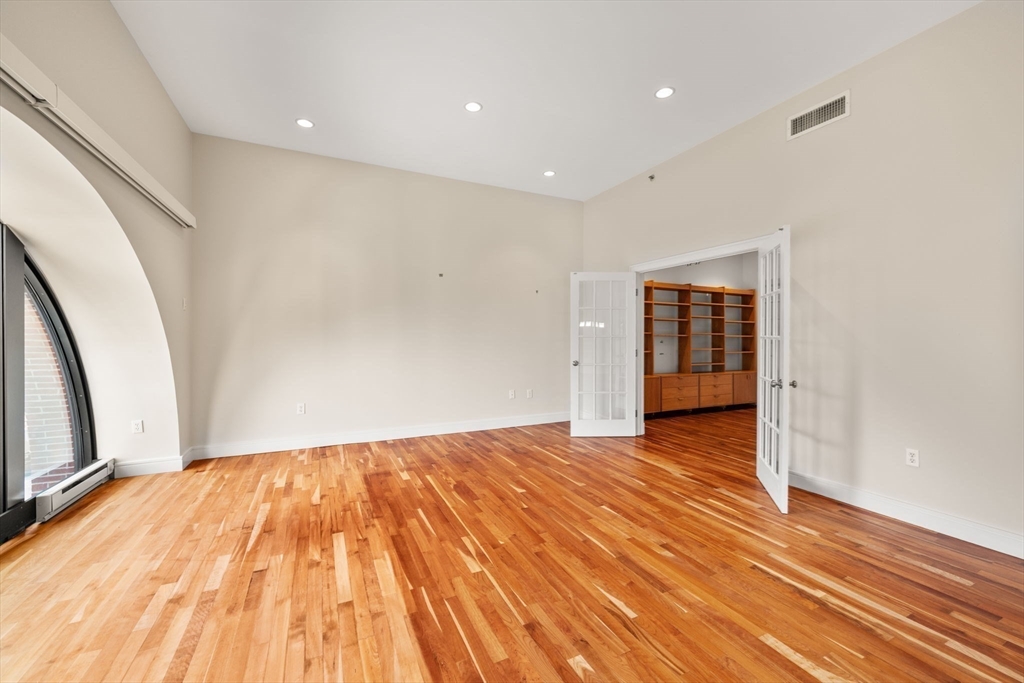 2420 Beacon Street, Unit 402 Boston, MA 02467 - Photo 18 of 29 a view of an empty room with wooden floor and stairs