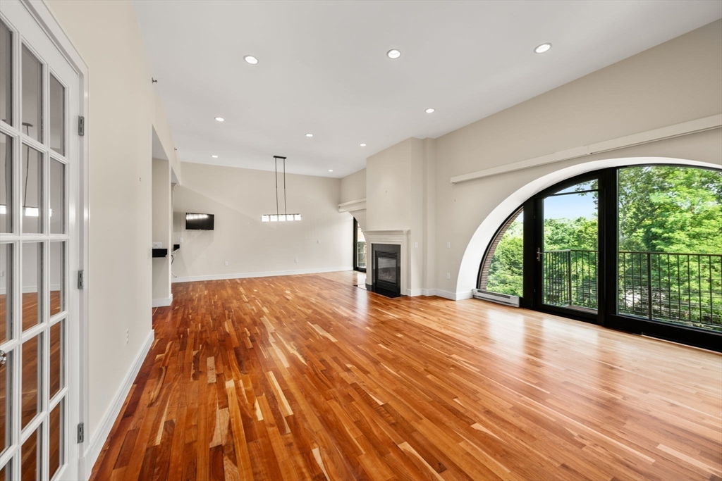 2420 Beacon Street, Unit 402 Boston, MA 02467 - Photo 23 of 29 a view of an empty room with a floor to ceiling window and wooden floor