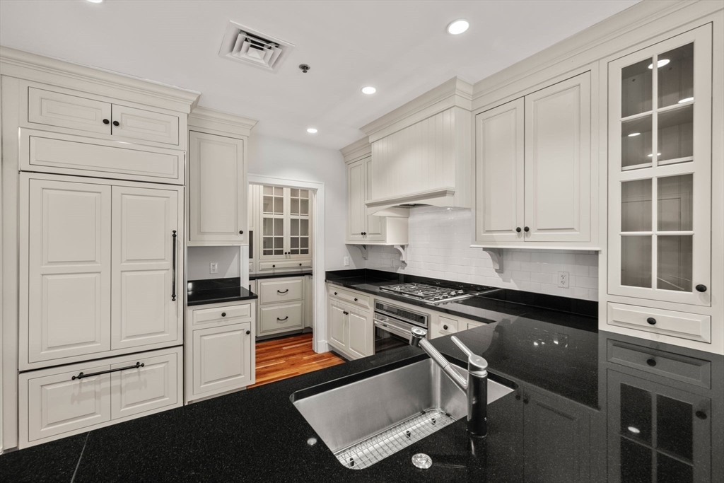 2420 Beacon Street, Unit 402 Boston, MA 02467 - Photo 5 of 29 a kitchen with granite countertop white cabinets and white appliances