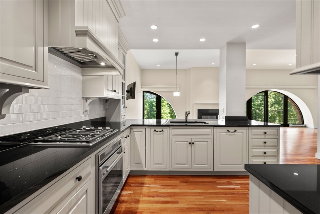 2420 Beacon Street, Unit 402 Boston, MA 02467 - Photo 8 of 29 a kitchen with stainless steel appliances granite countertop a stove a sink and a microwave