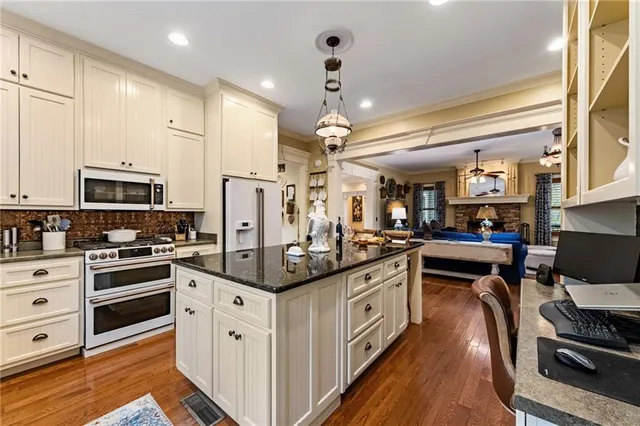 a kitchen with stainless steel appliances granite countertop a sink dishwasher and cabinets with wooden floor
