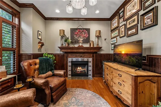 a bedroom with a bed a chandelier and a dresser next to a window